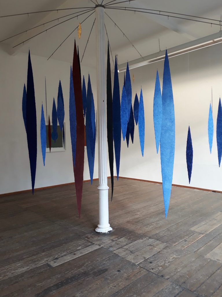 An der Ausstellung papier = kunst 9 im NKV Aschaffenburg im KunstLANDing nimmt Helmut Dirnaichner mit einer Raumarbeit aus 48 geschöpften, schwebenden Lanzettformen aus Lapislazuli und Zinnober teil.