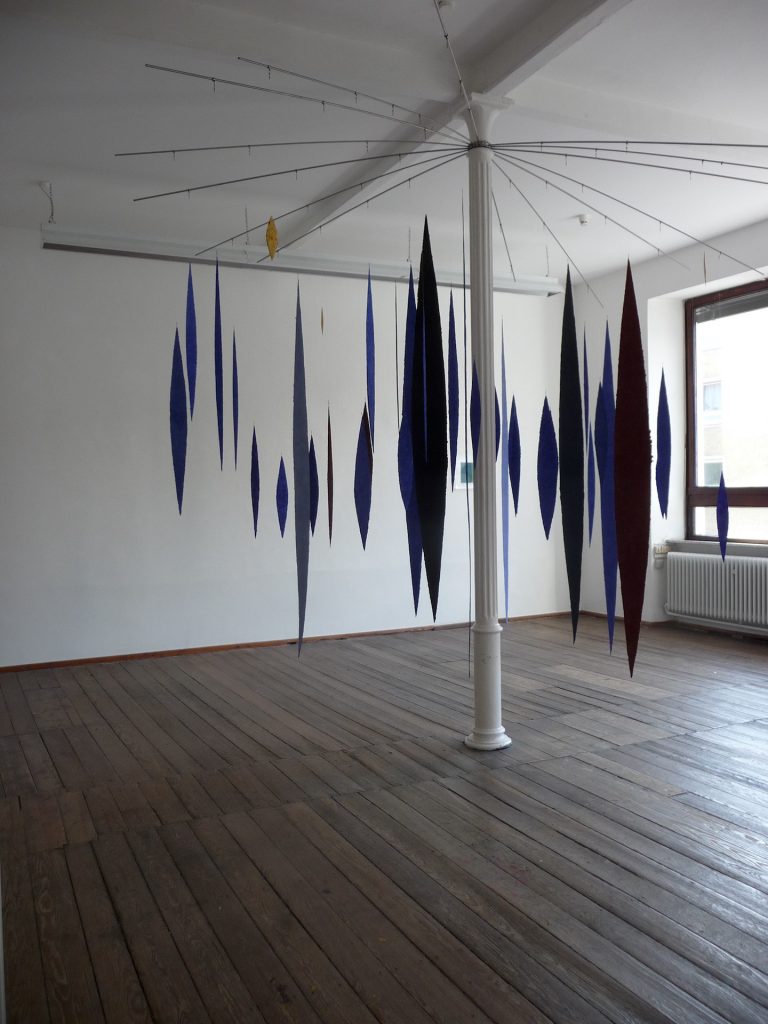 An der Ausstellung papier = kunst 9 im NKV Aschaffenburg im KunstLANDing nimmt Helmut Dirnaichner mit einer Raumarbeit aus 48 geschöpften, schwebenden Lanzettformen aus Lapislazuli und Zinnober teil.