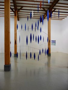 Blick auf zwei Werke von Helmut Dirnaichner in der galerie hoffmann, Ausstellungshalle Friedberg Ossenheim 2011-2012: Im Vordergrund Lichtsteine, 2008-2011, Lapislazuli, Jaspis, Gold, Zellulose, im Hintergrund mare, 16teilig, 2010.