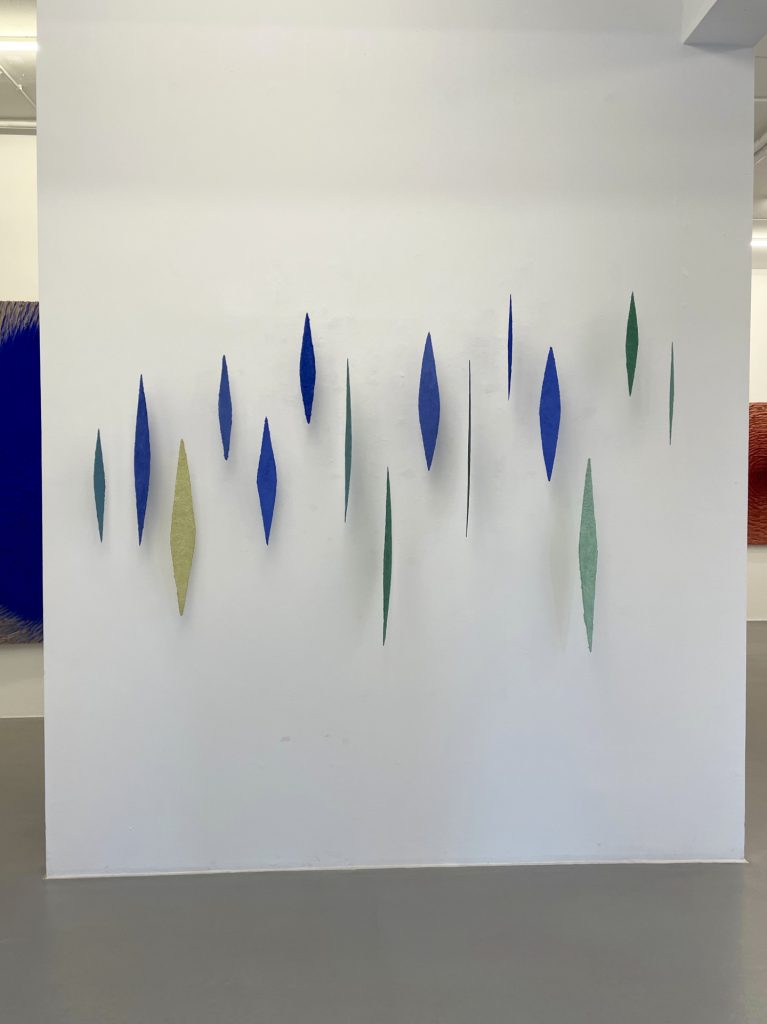 Lapislazuli Azurit ist ein Werk von Helmut Dirnaichner aus dem Jahr 2010, mit schwebenden, lanzettförmigen Objekten aus Lapislazuli, Azurit, Malachit und Zellulose